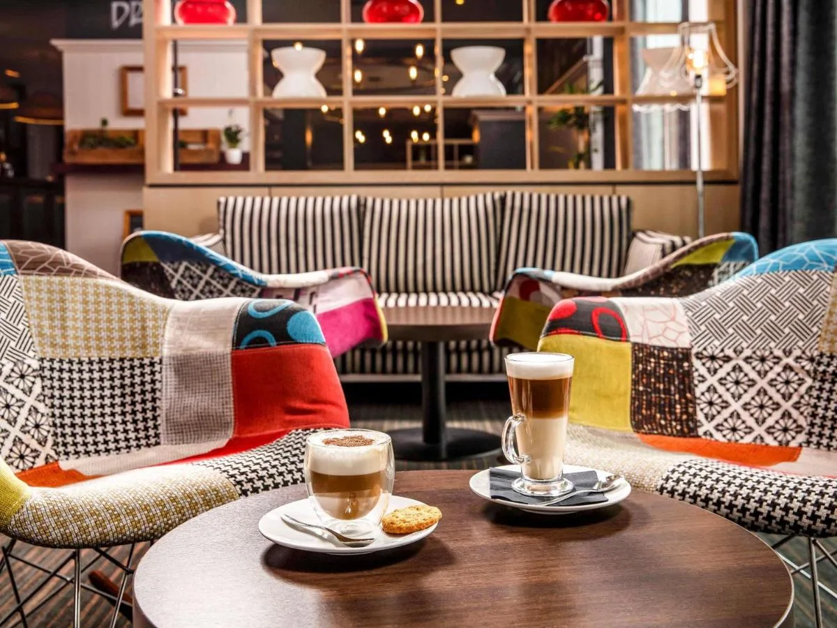 two cups of coffee sitting on a table with chairs at ibis Bristol Temple Meads in Bristol