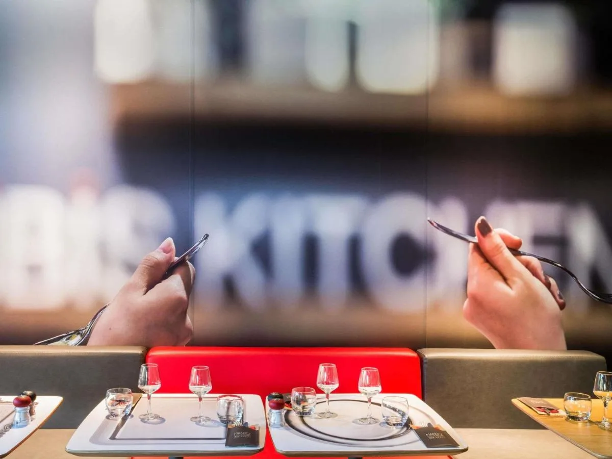a person sitting at a table with their hands holding a cigarette at ibis Bristol Temple Meads in Bristol