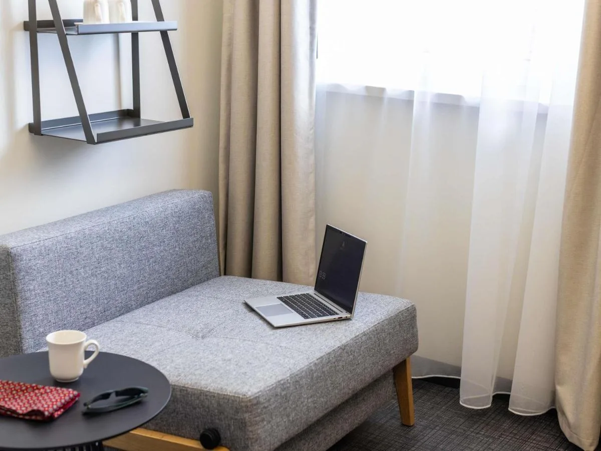 a laptop computer sitting on a couch with a table at ibis Bristol Temple Meads in Bristol